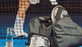 Bolsa de deporte elegante en pista de pádel con raqueta y zapatillas