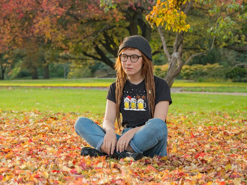 Persona con camiseta negra estampada en un parque, ejemplo de camisetas estampadas para diferentes estilos y edades.